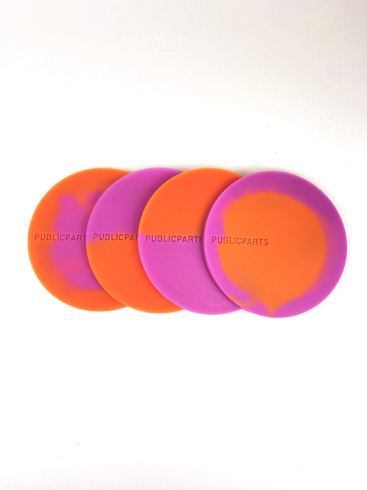 Stacked orange and pink thermochromic silicone coasters showing colour variation.