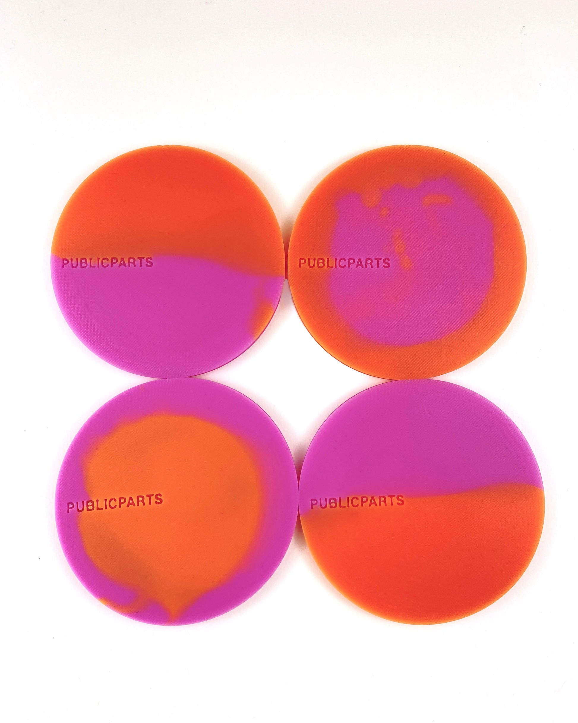 Set of four orange and pink heat-reactive silicone coasters hand-poured in London