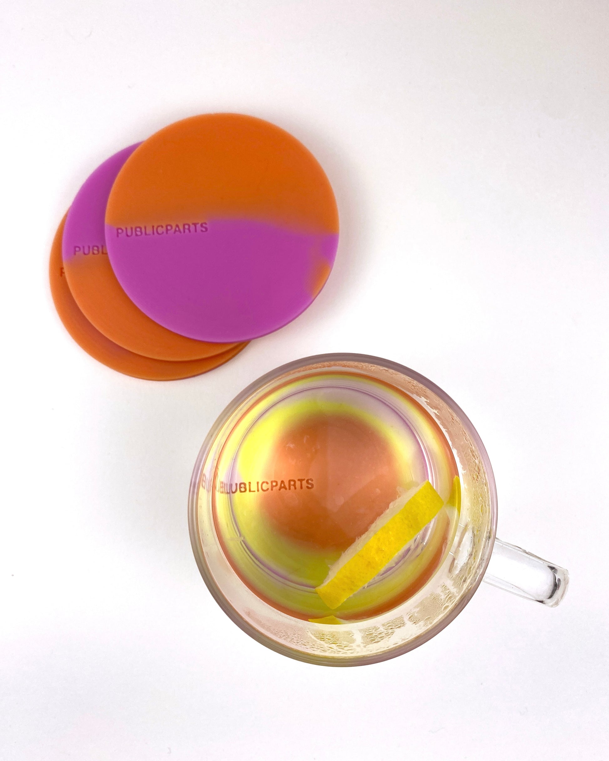Heat-reactive silicone coasters showing colour change from pink and orange to yellow and lilac.