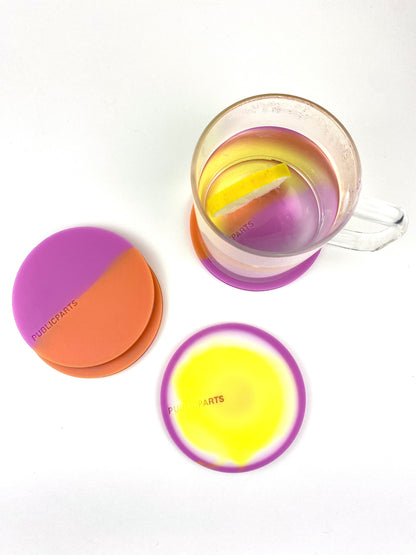 Glass mug on heat-sensitive silicone coaster showing yellow colour shift when warm.